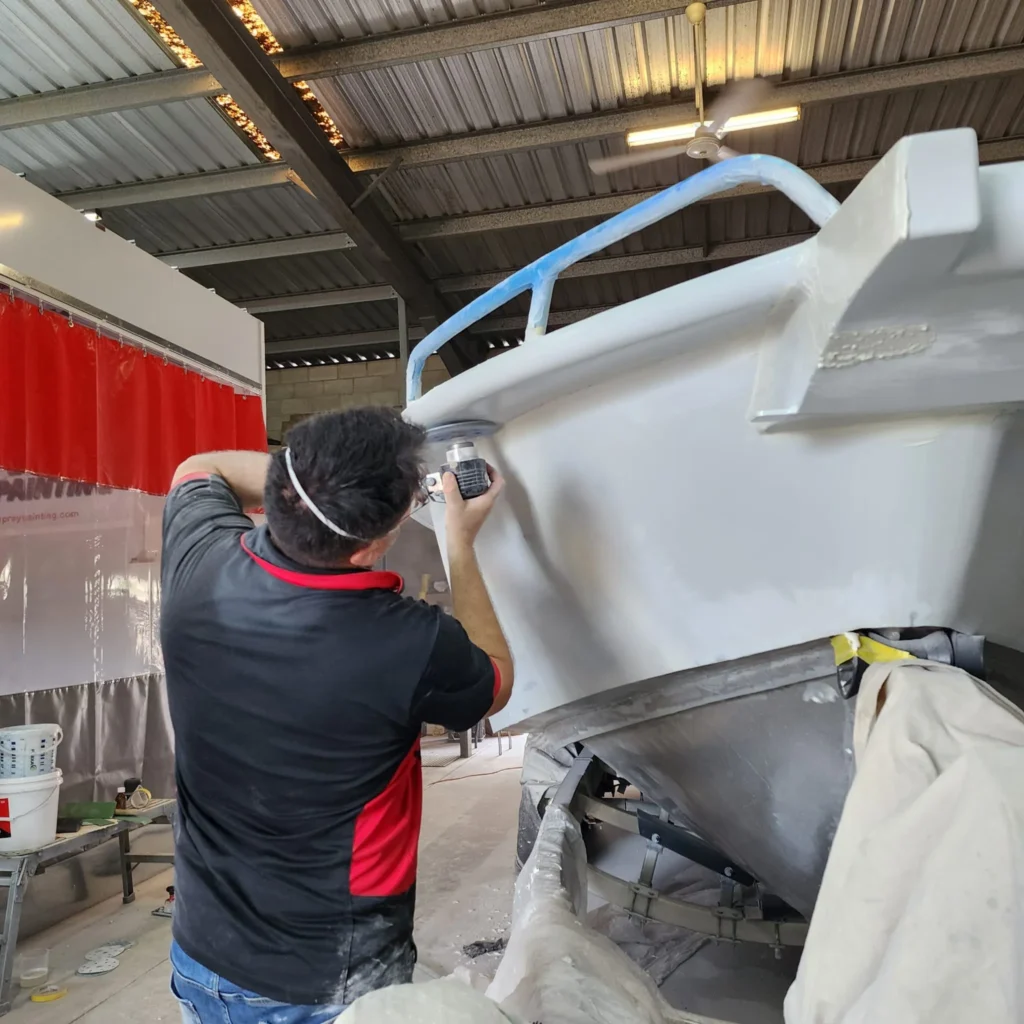 Spray painting the hull exterior of a boat in Darwin